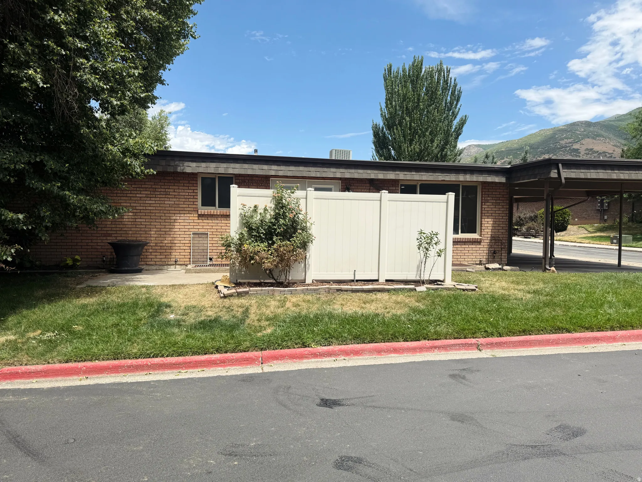 Brick exterior with multiple windows and a carport