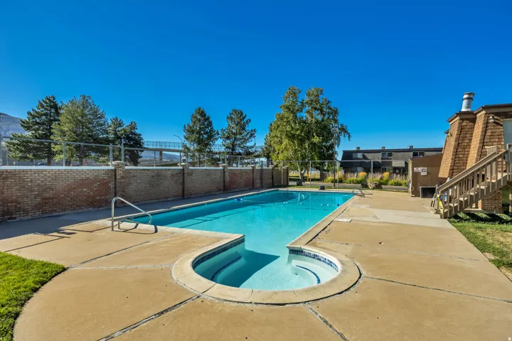 Outdoor swimming pool with integrated spa and concrete surround