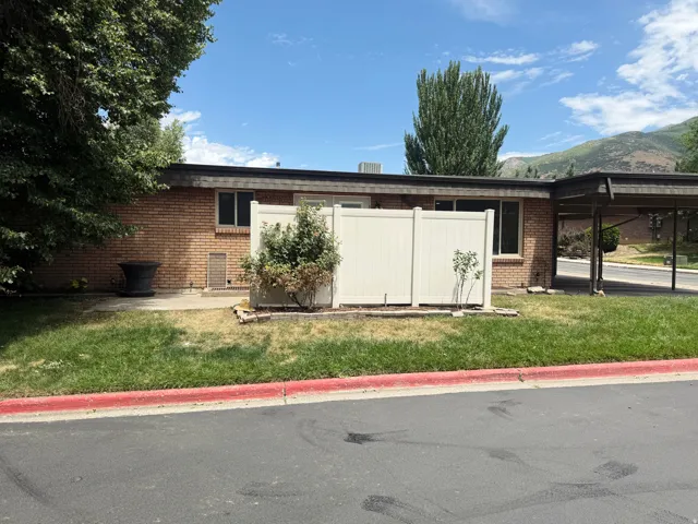 Brick exterior with multiple windows and a carport