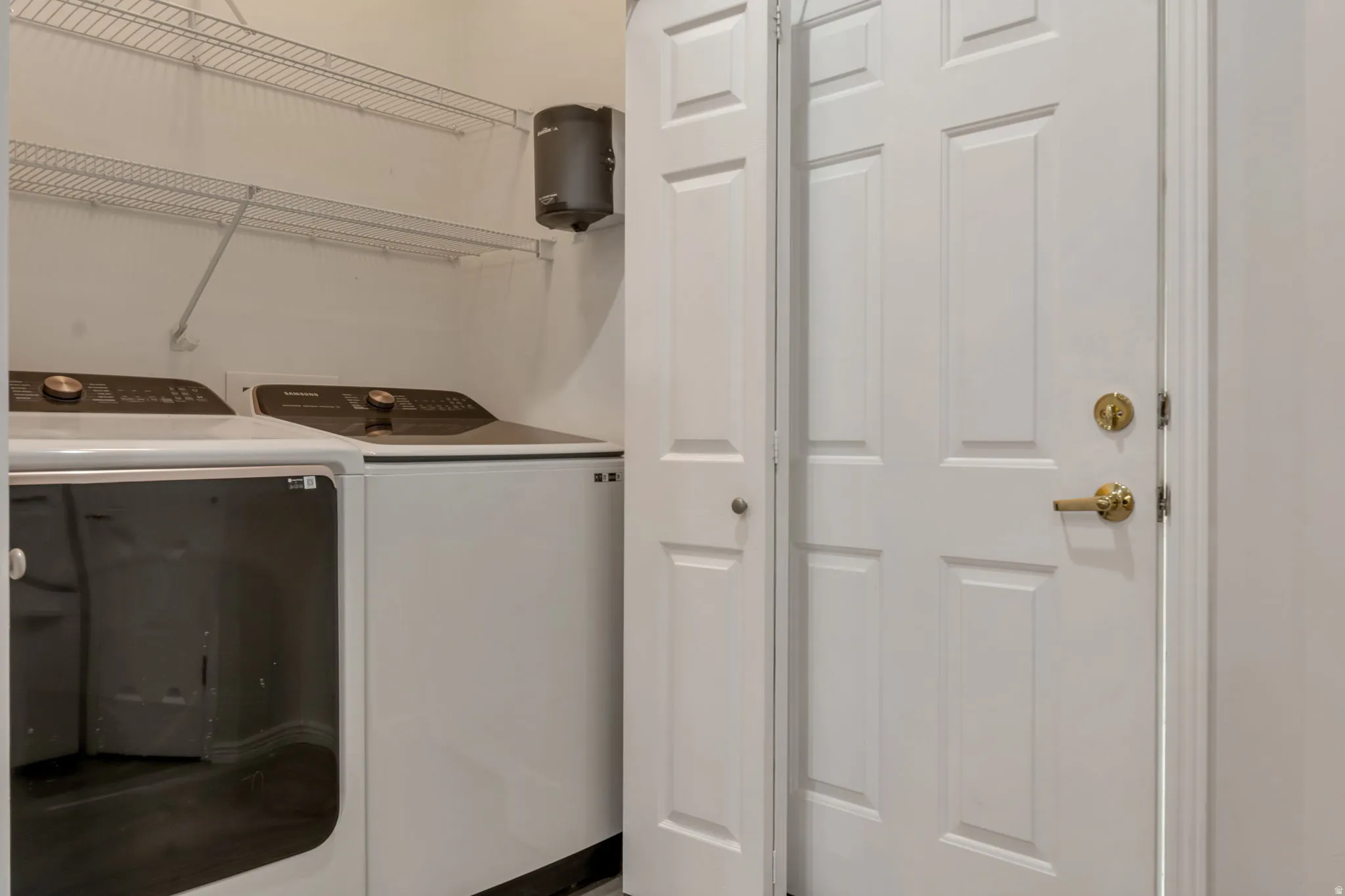 Utility area featuring shelves. Laundry room is immediate from garage entry