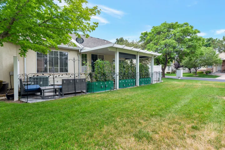 Back patio/ yard featuring pergola, and decorative raised garden beds, quick access to clubhouse and pool
