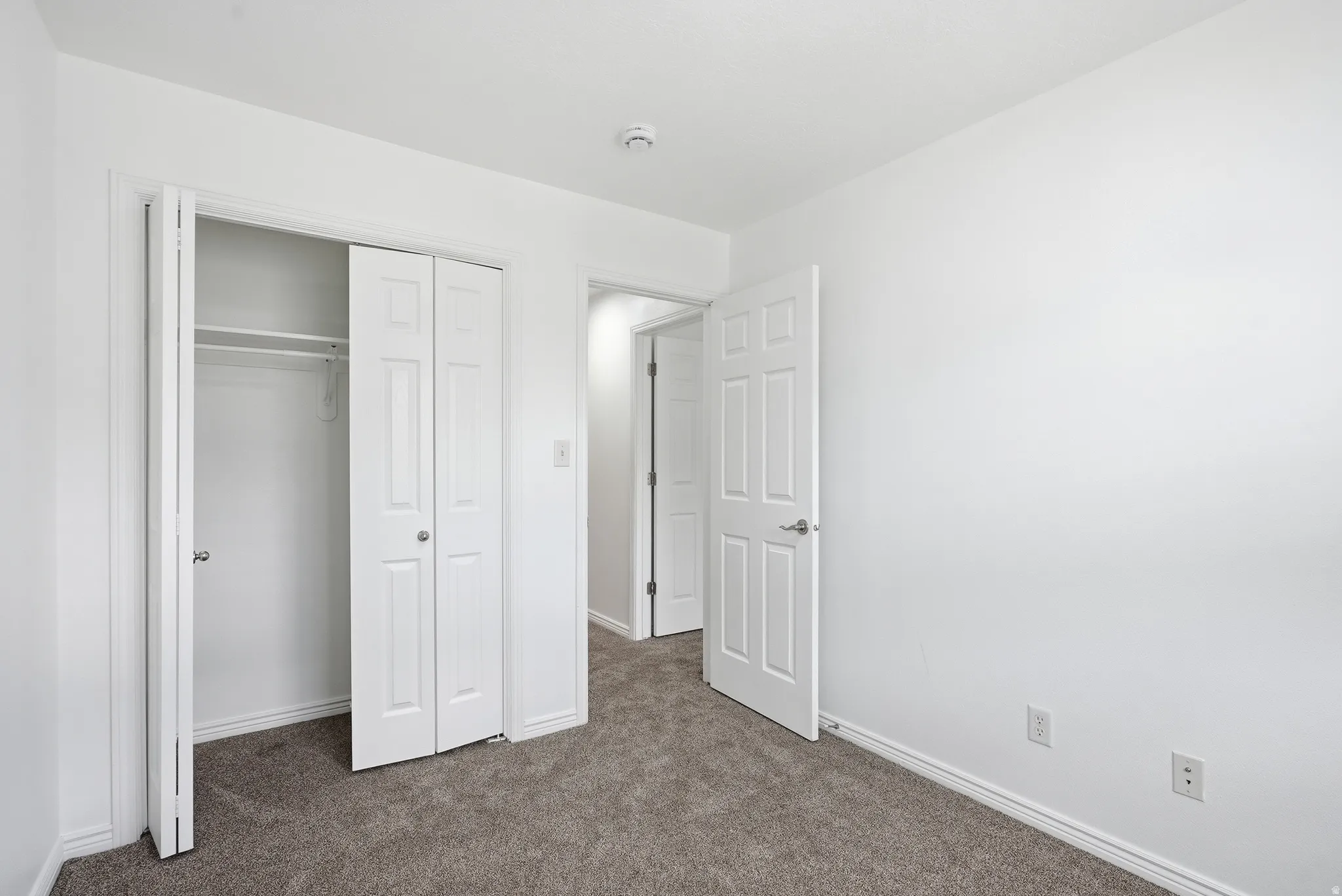 Neutral white walls complement the gray carpeting