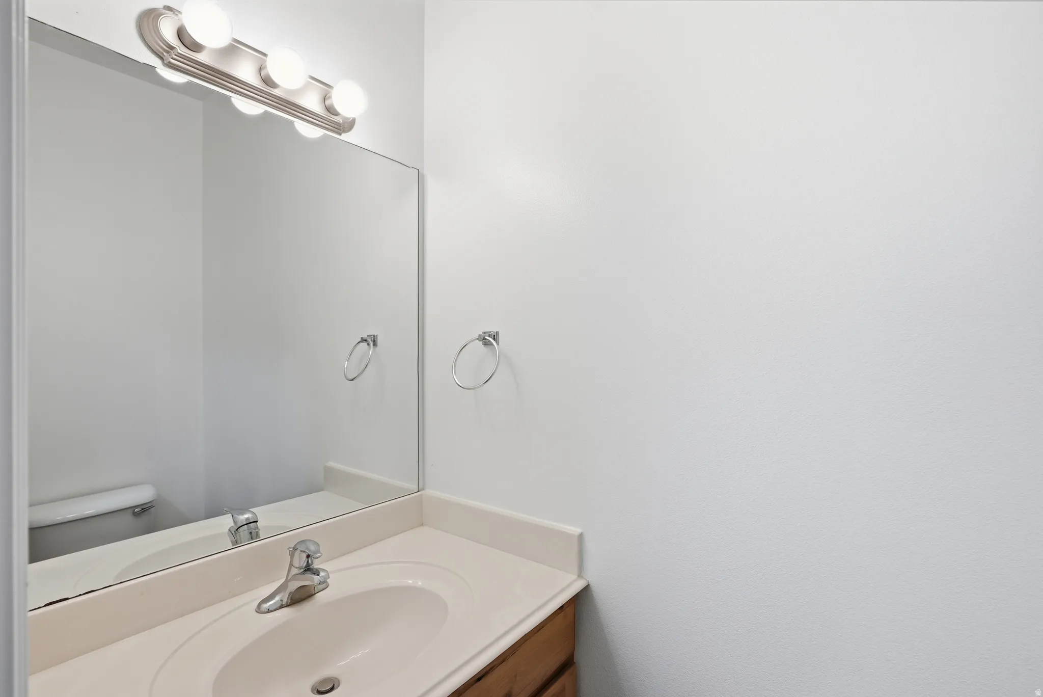 Vanity with an integrated sink, polished chrome faucet, and a light-toned countertop