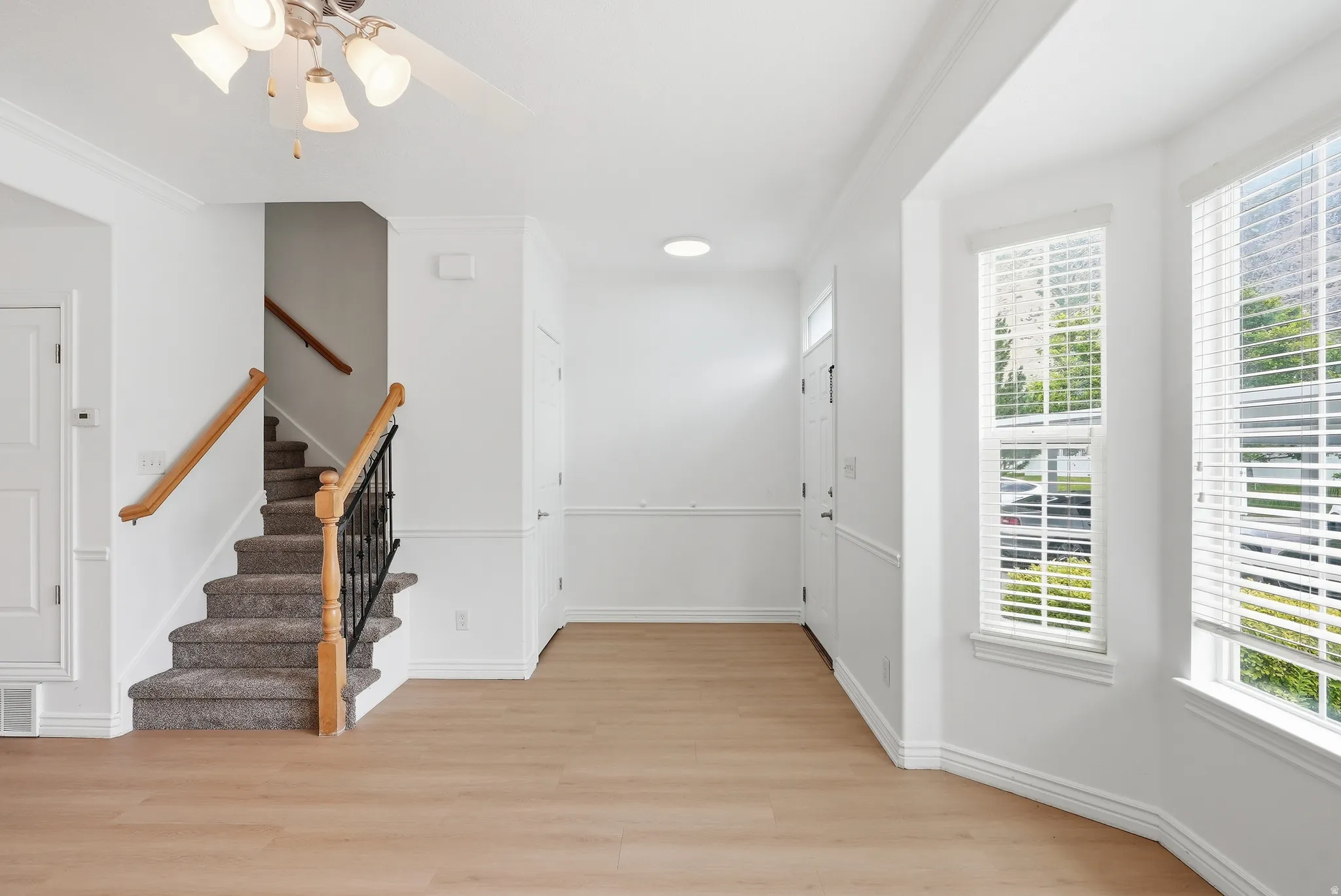 Light wood-finish flooring complements the white wall finishes and crown molding