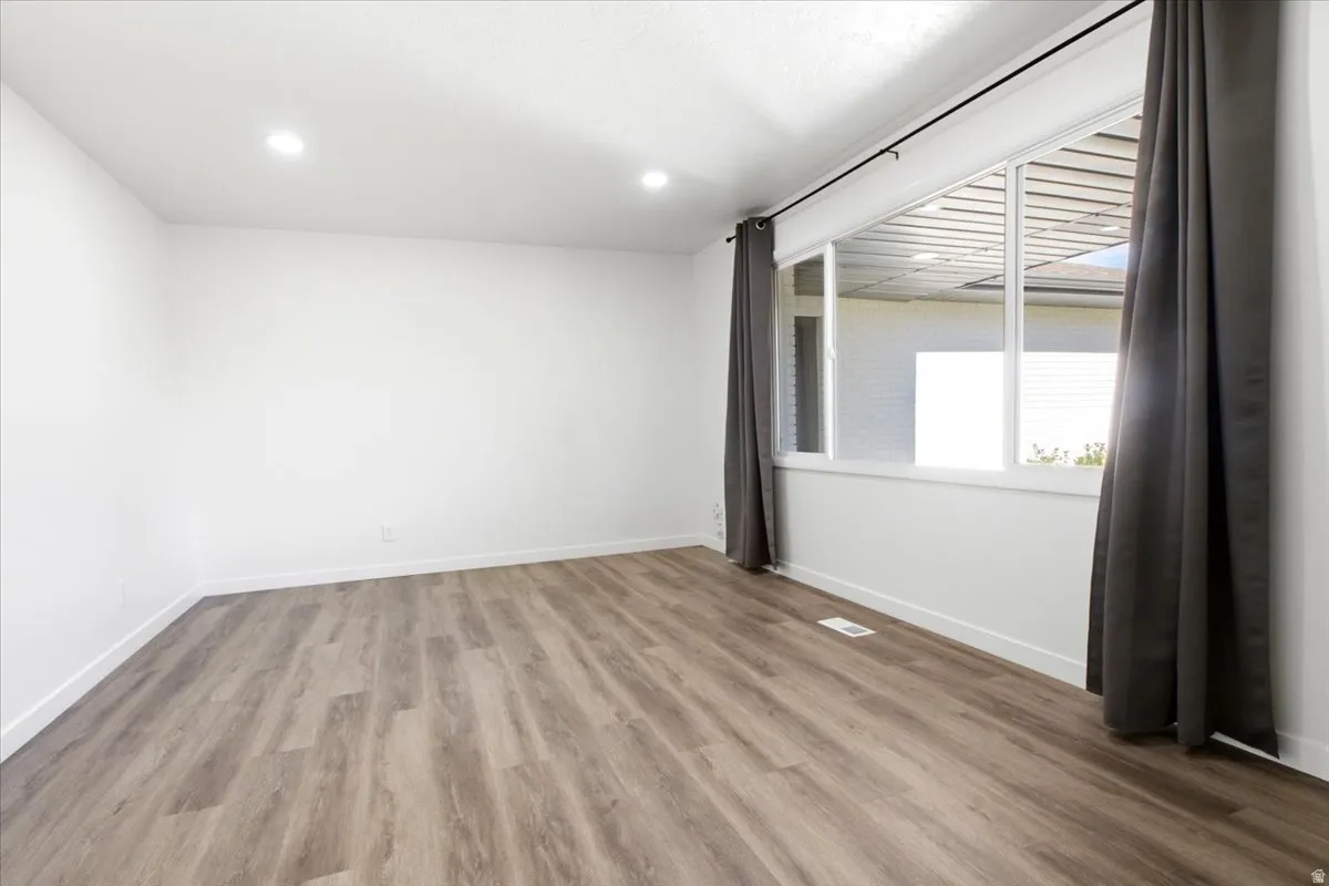 Bright interior space featuring wood-finish flooring, recessed lighting, and a large multi-pane window