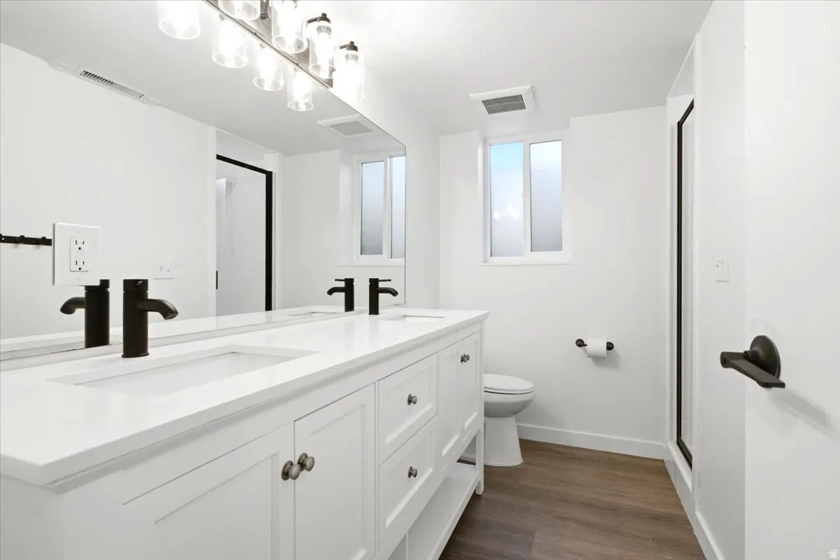 Double vanity with integrated sinks, matte black faucets, and brushed nickel hardware