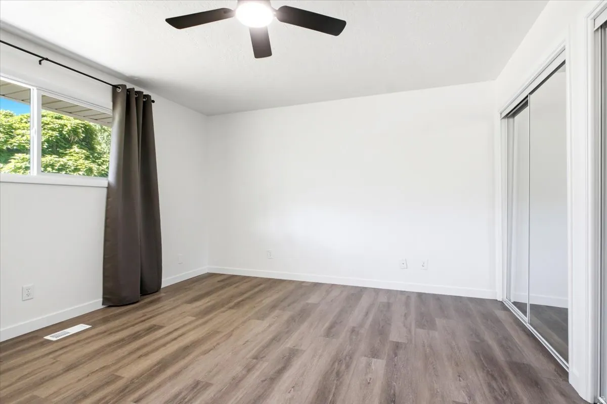 Room with wood-finish flooring, white walls, and white trim