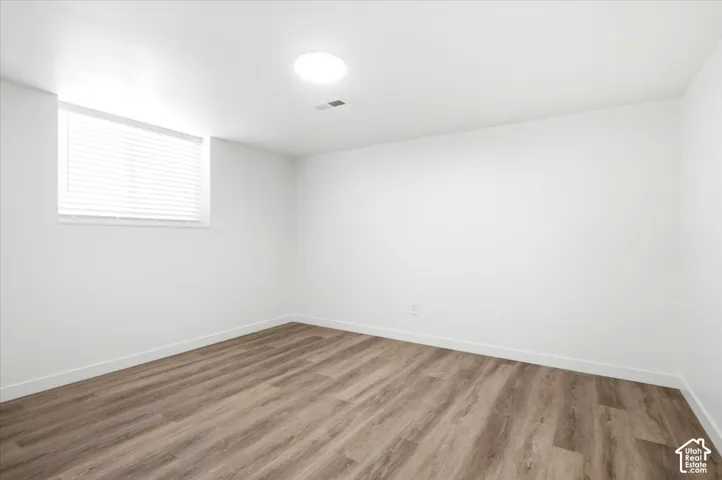 Bright room featuring wood-finish flooring and a white color palette