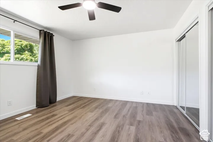 Room with wood-finish flooring, white walls, and white trim