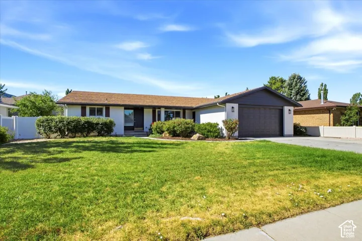 Ranch-style residence featuring a brown shingle roof, white painted brick, and dark shutters