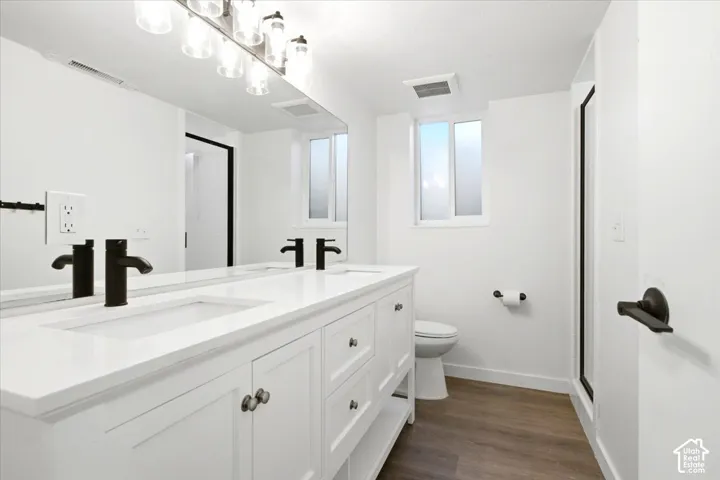 Double vanity with integrated sinks, matte black faucets, and brushed nickel hardware