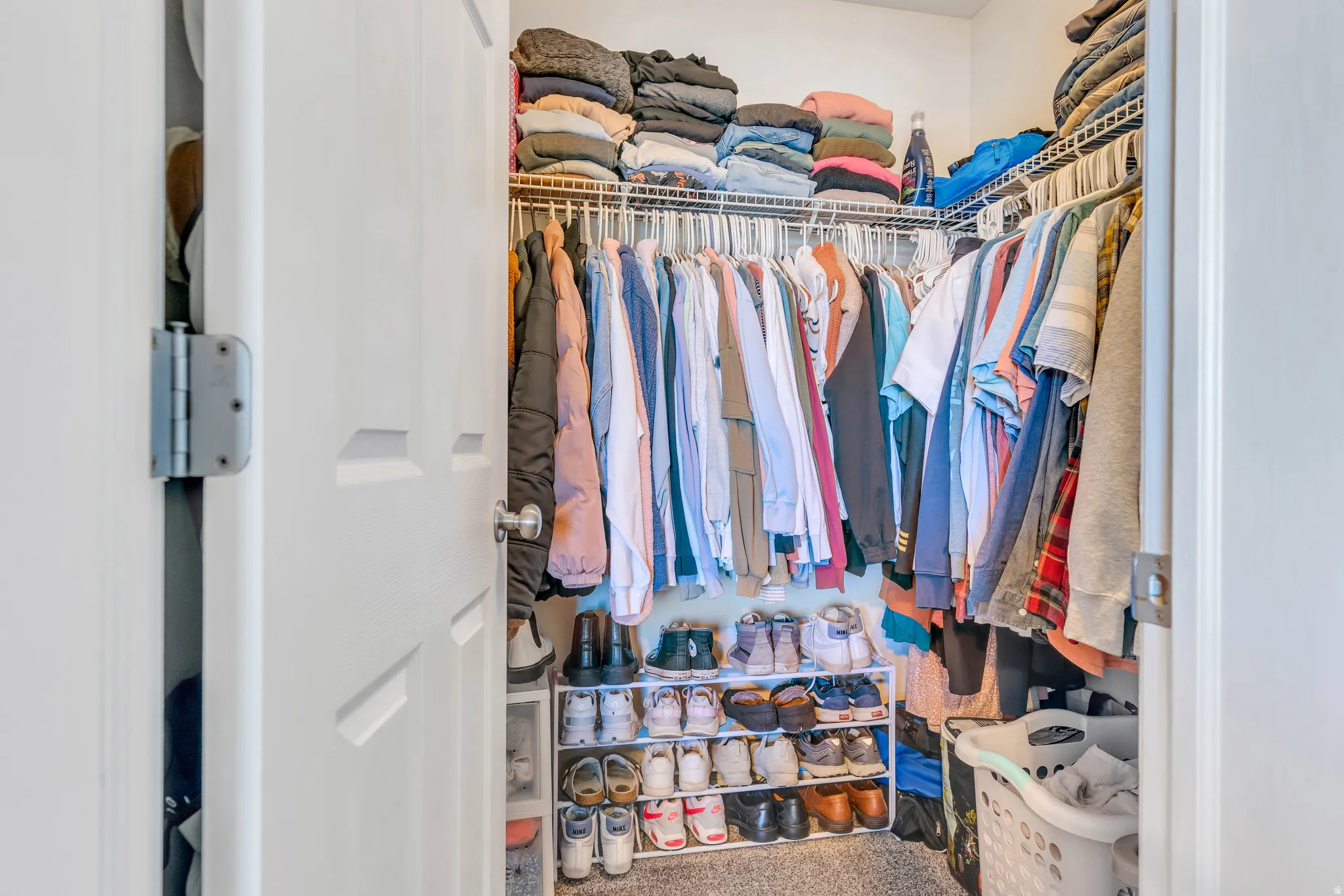 Walk-in closet featuring built-in wire shelving and hanging rods