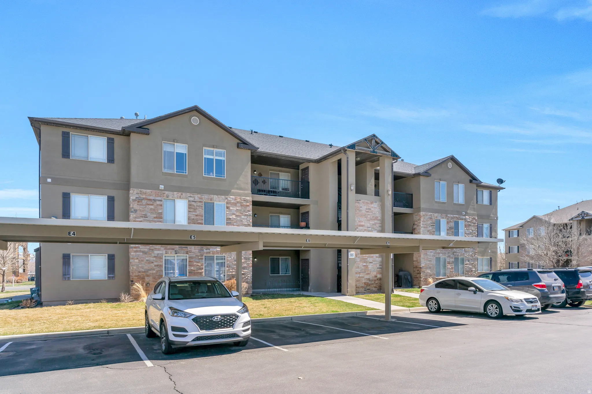 Multi-story residential building with stucco and stone veneer facade