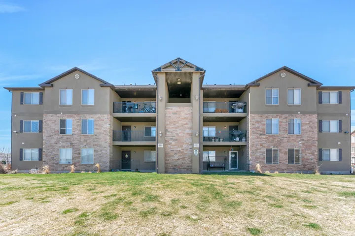 Multi-story building exterior featuring a combination of stone veneer and stucco siding