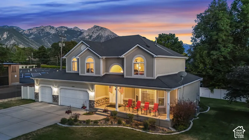 Two-story stucco property featuring a dark shingle roof and prominent arched windows
