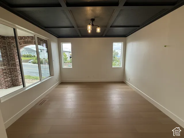 Coffered ceiling with a dark finish, wood-finish flooring, and multi-light pendant fixture
