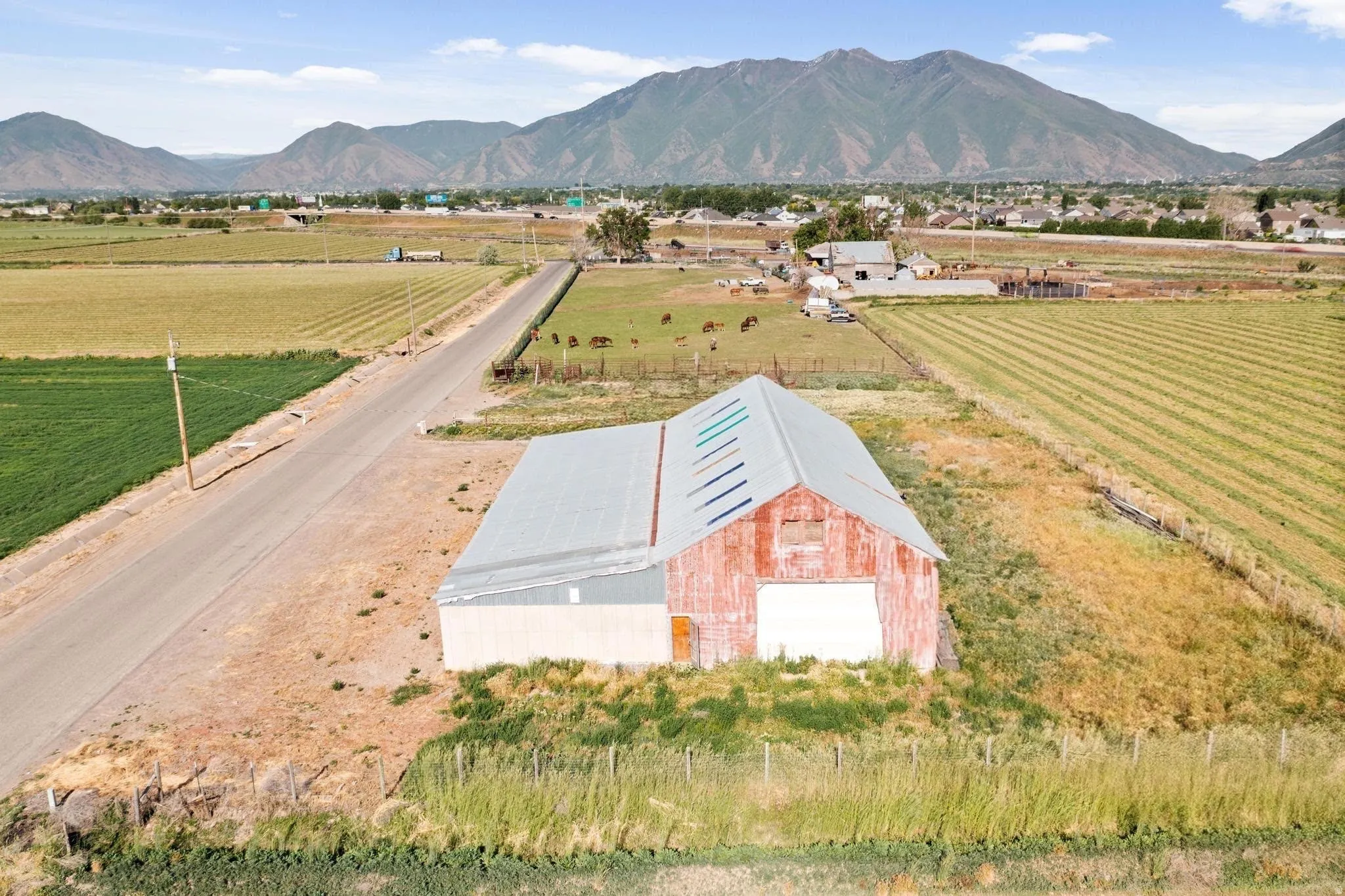 Red barn structure with a metal roof and large white garage door