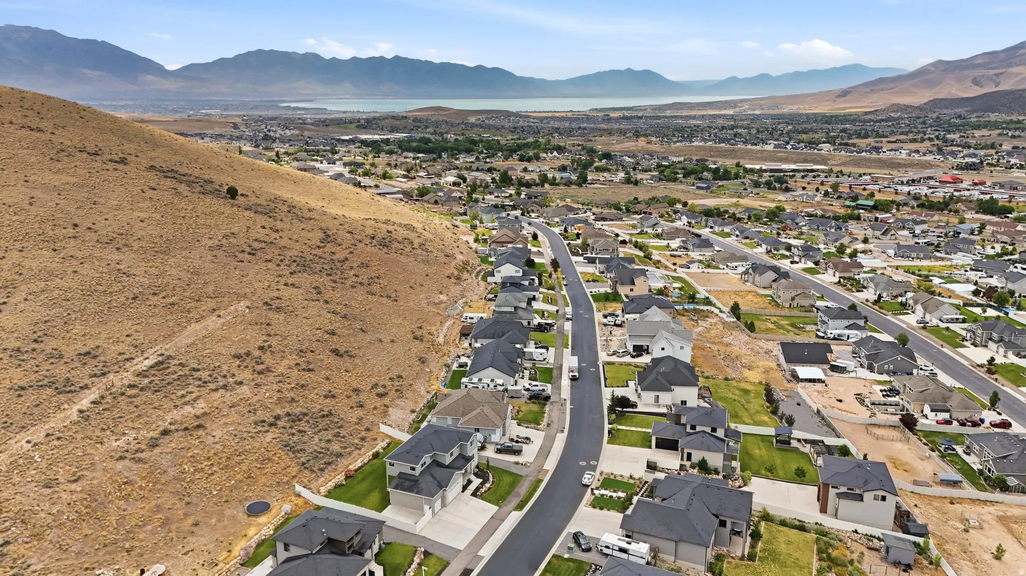 Expansive elevated neighborhood featuring contemporary single-family homes with dark roofs and light-colored exteriors