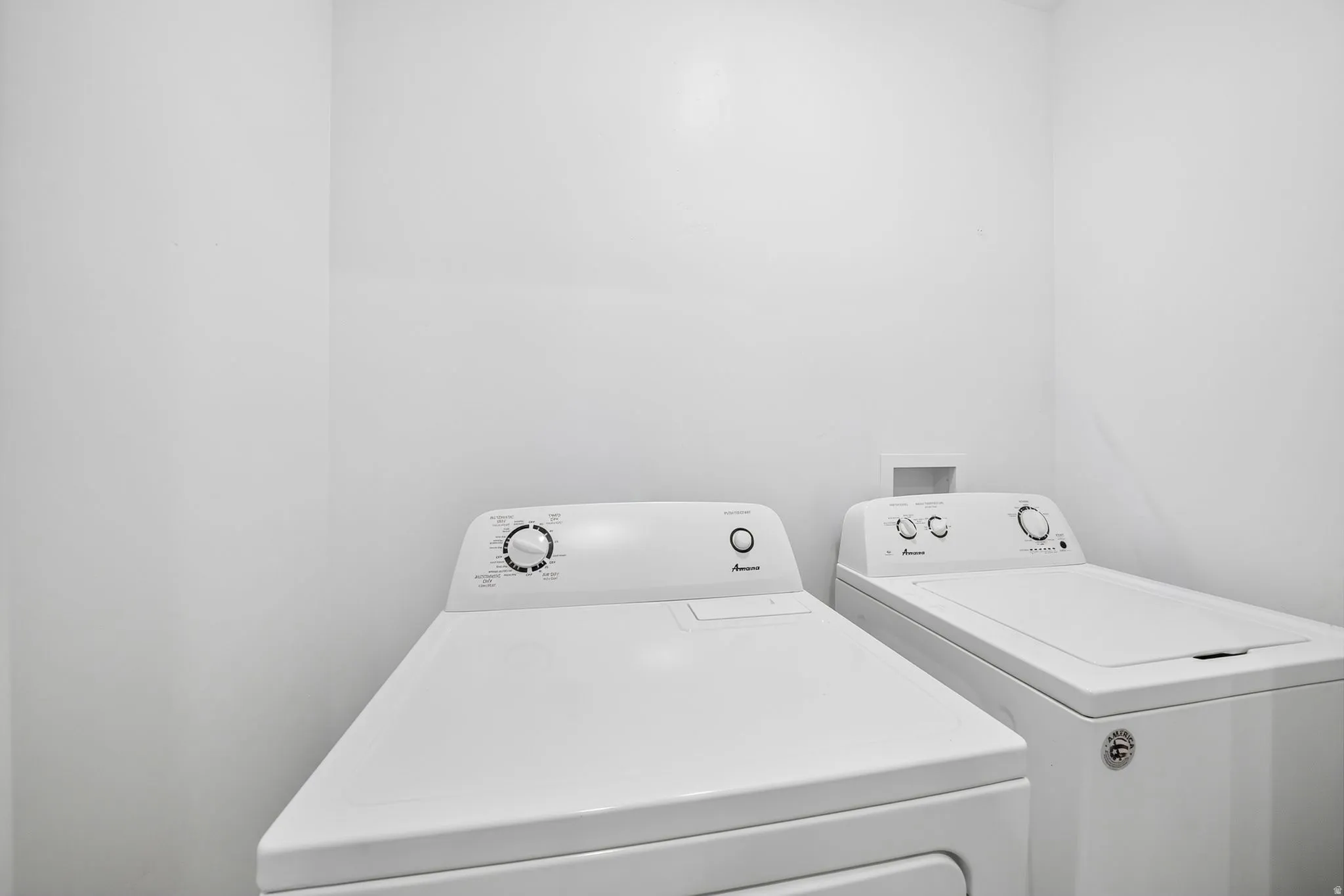 Dedicated basement laundry area featuring a top-load washing machine and a front-load dryer