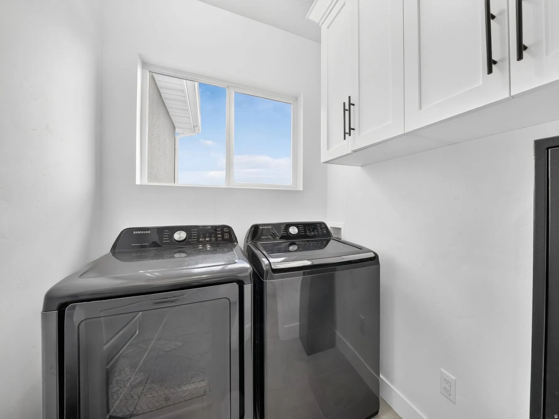 Second-floor dedicated laundry space featuring cabintrey.