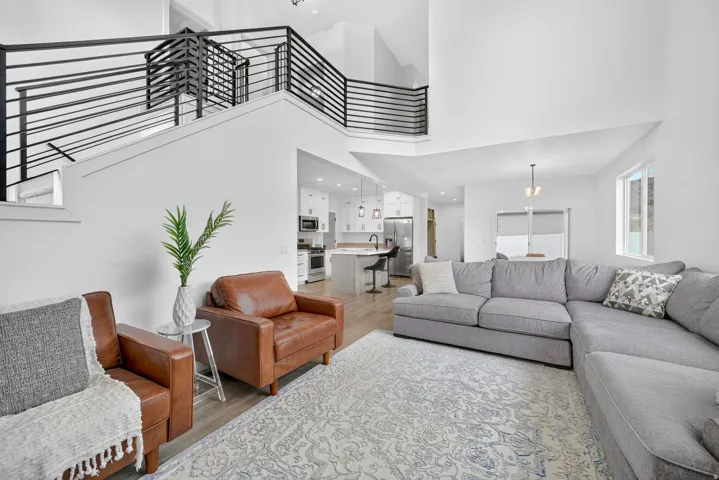 Open-concept living space with high ceilings and light wood-finish flooring
