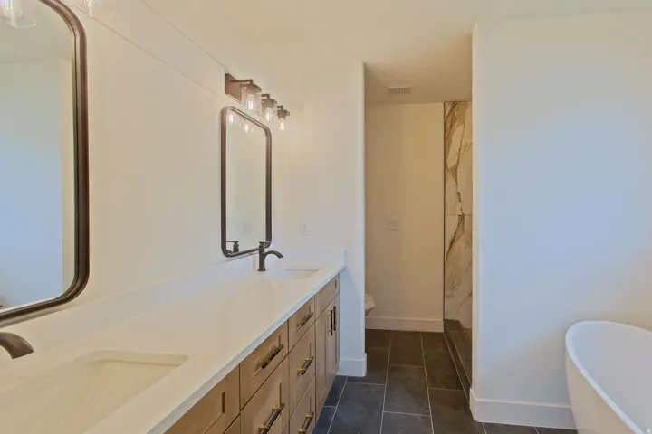 Dual vanity featuring integrated sinks, white countertops, and wood-finish cabinetry with dark hardware