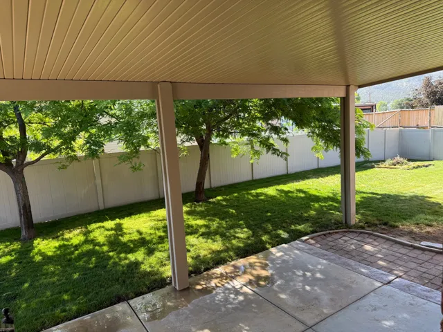 Covered patio with a smooth concrete surface and decorative paver inlay