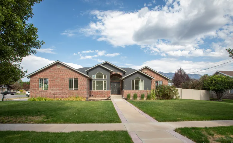 Brick and stucco exterior with multiple gables and a dark shingle roof