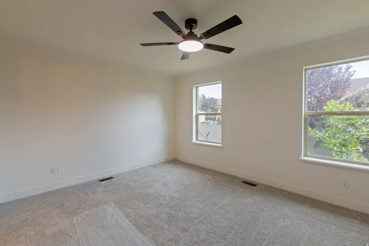 Neutral white walls complement a gray carpeted floor