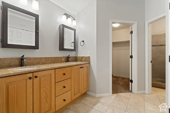 Owner's ensuite featuring dual vanity with light wood cabinetry
