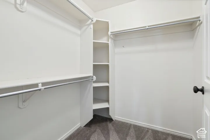 Walk-in closet featuring built-in shelving and multiple hanging rods