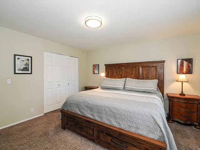 Carpeted bedroom featuring a flush-mount ceiling light and neutral wall paint