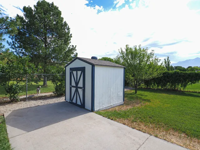 White storage shed with a dark trim and double barn-style doors