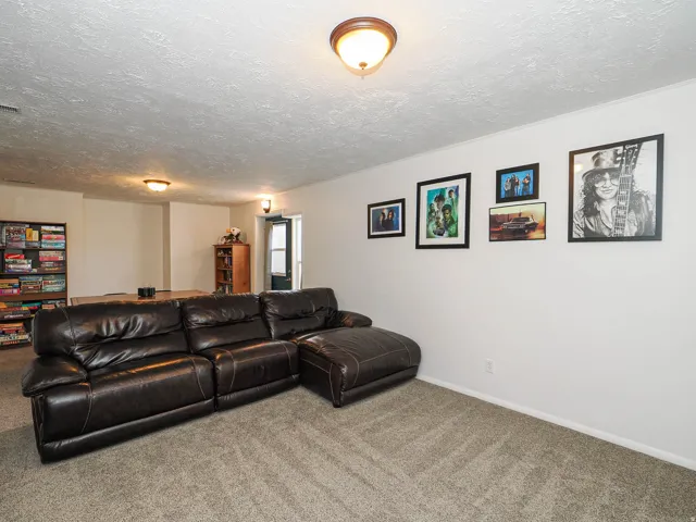 Expansive room featuring light gray carpet flooring and white walls