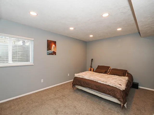 Carpeted room featuring recessed lighting, a window with blinds, and light-colored walls