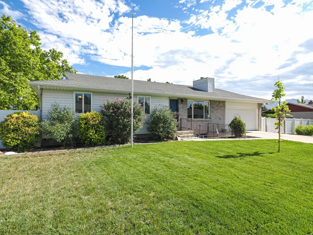 Ranch-style residence featuring a prominent front lawn and mature landscaping