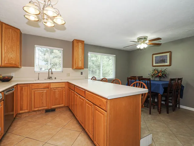 Kitchen featuring oak-finish cabinetry, light countertops, and tile flooring