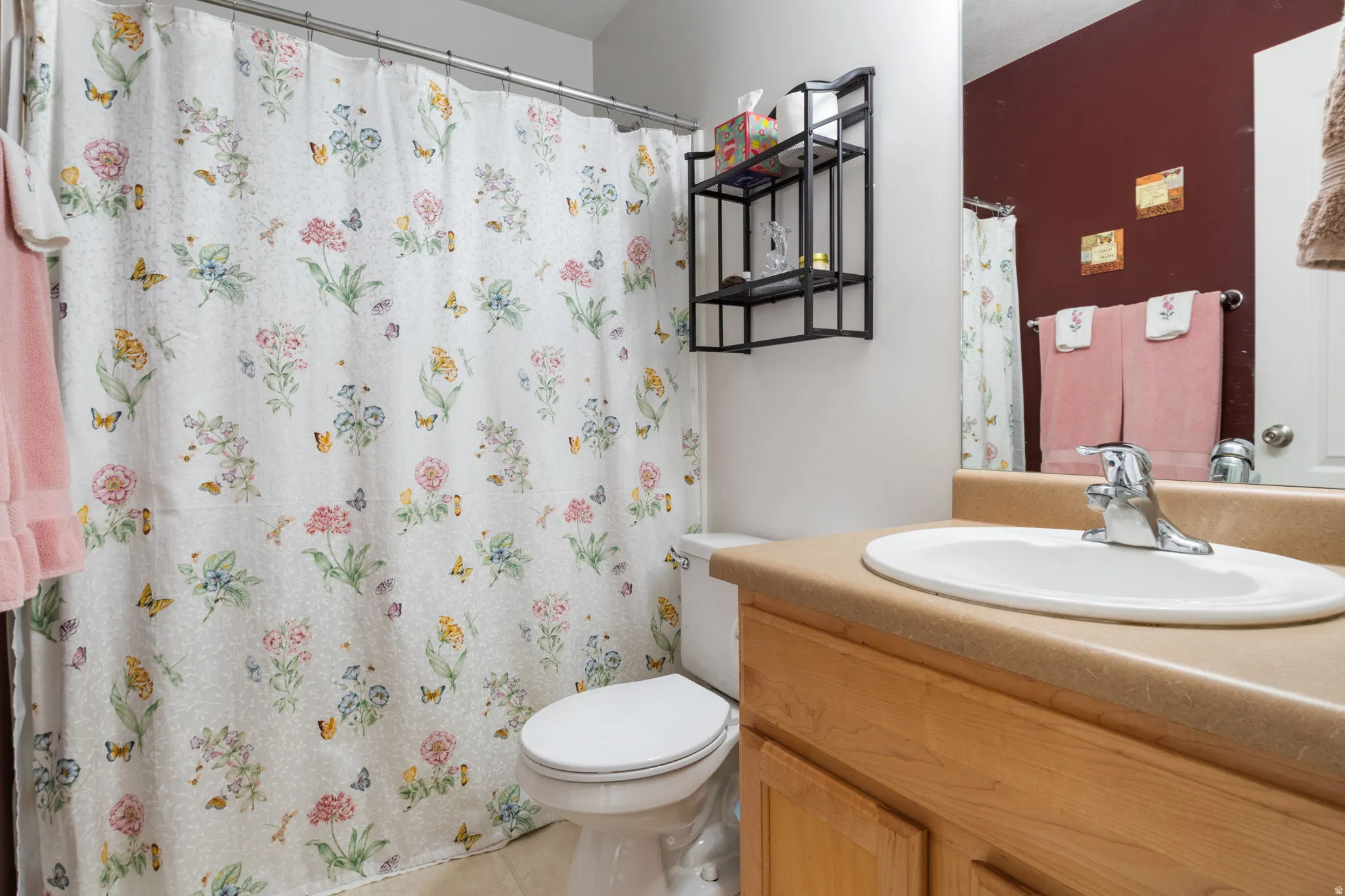 Bathroom featuring a single vanity with an integrated sink, chrome faucet, and wood-finish cabinetry