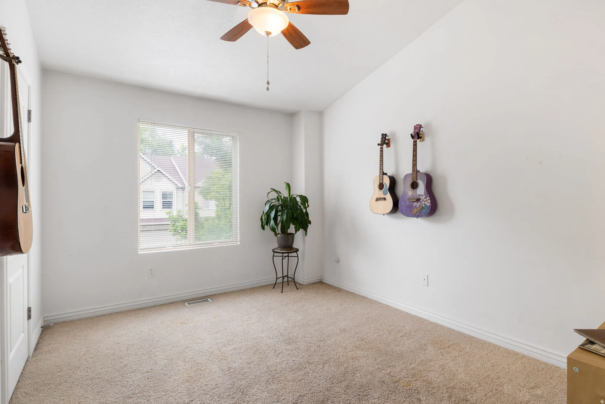 Carpeted room featuring a ceiling fan with integrated lighting, a single window, and white trim