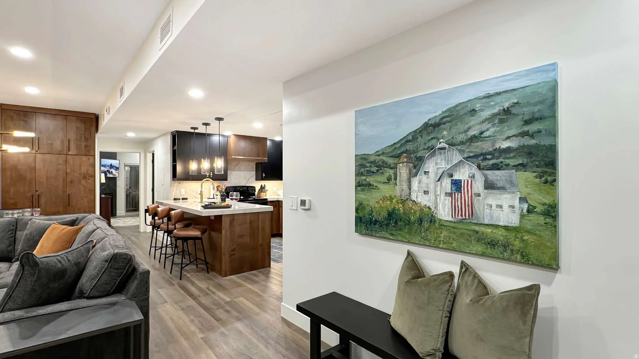 Open concept living space featuring wood-finish flooring, recessed lighting, and a modern kitchen