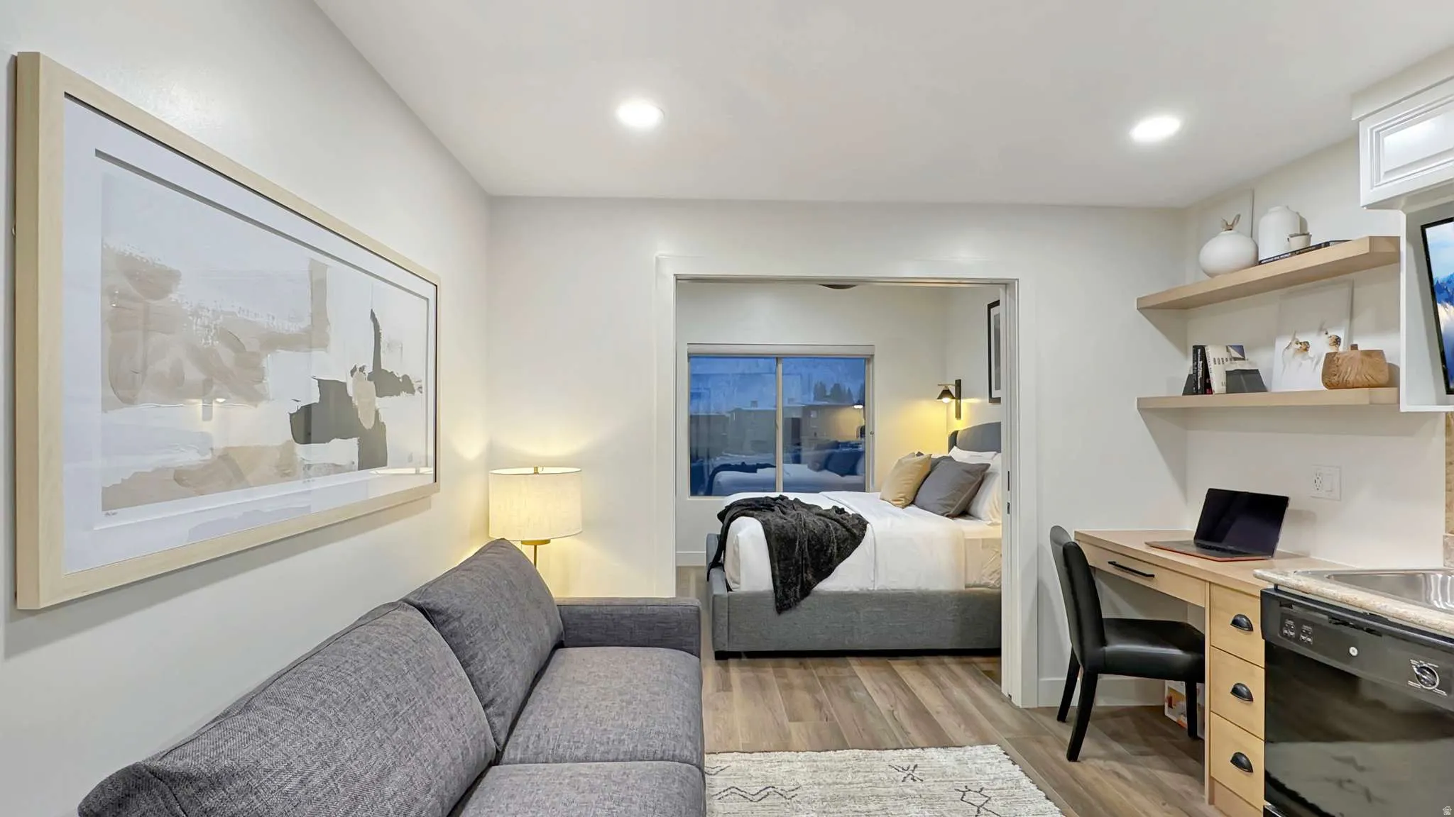 Open concept living area with wood-finish flooring, recessed lighting, and a dedicated workspace