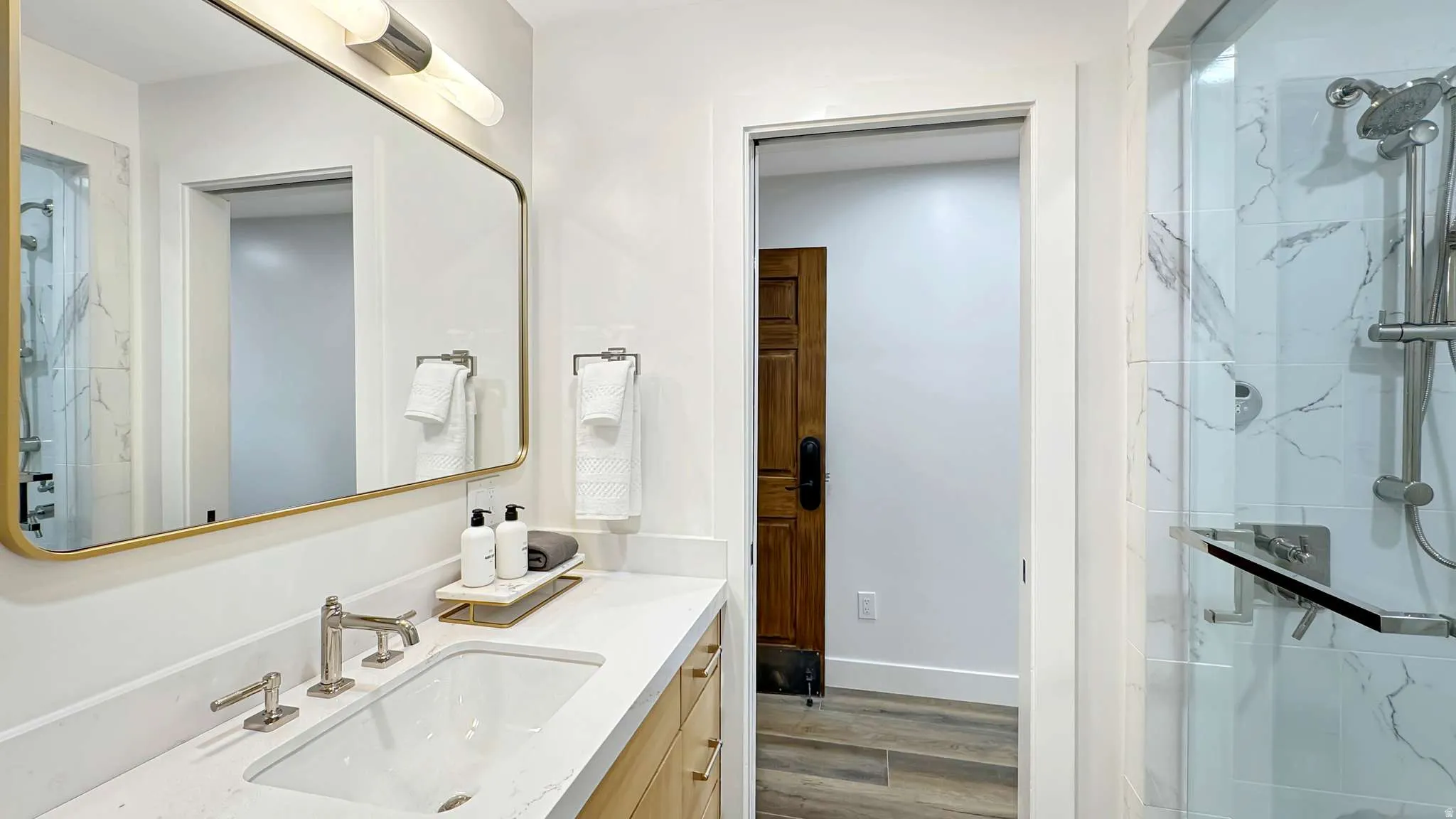Contemporary bathroom featuring a spacious vanity with an undermount sink and a light-toned countertop