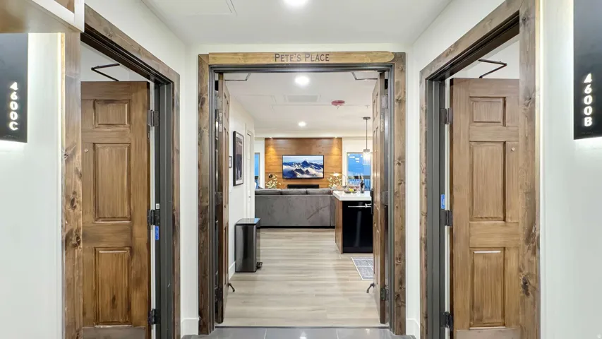 Entryway featuring three wood-paneled doors with dark wood trim