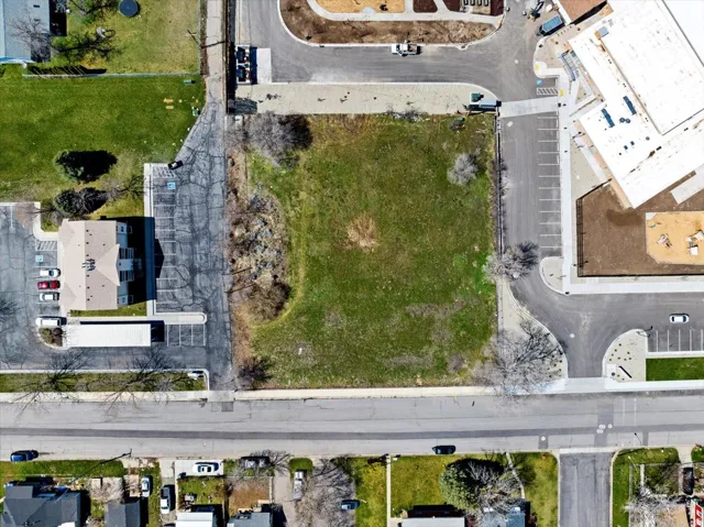 Expansive green space featuring a large, undeveloped lot with surrounding paved roads