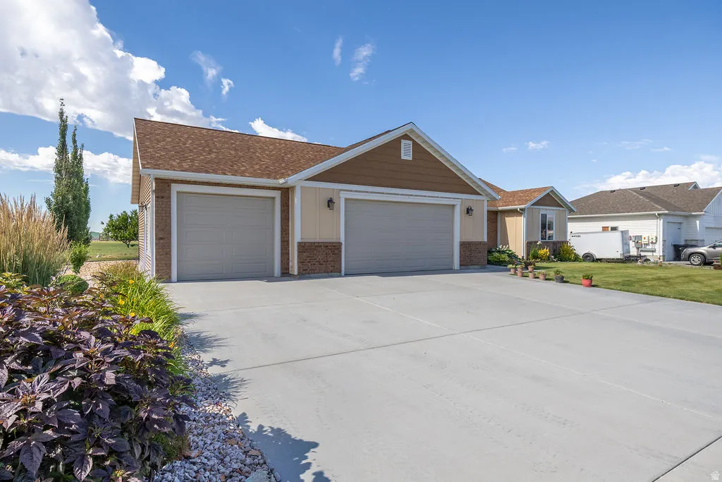 Triple-bay garage with overhead doors and exterior wall sconces