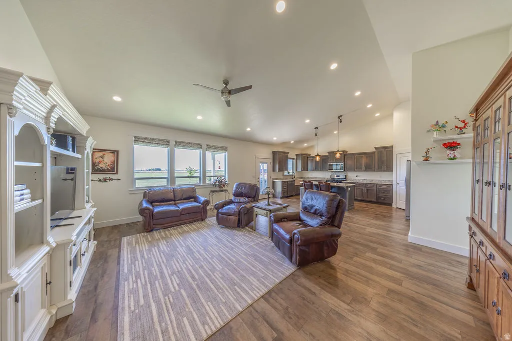 Open-concept living area featuring wood-finish flooring, recessed lighting, and a vaulted ceiling