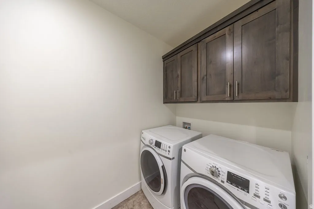 Dedicated laundry room with cabinets and counter top on other side of washer and dryer