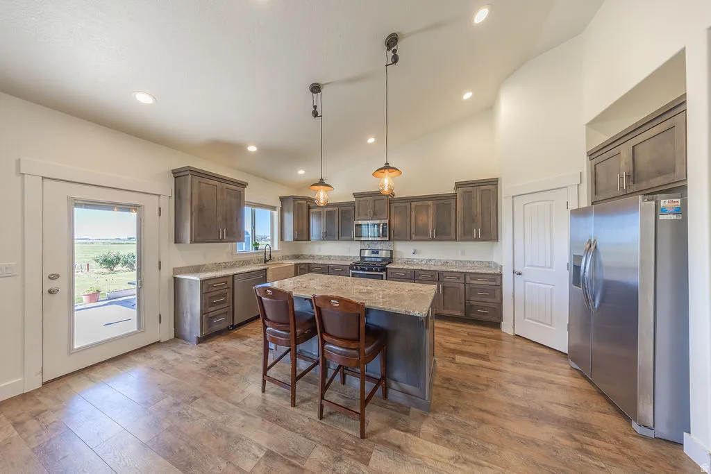 Island, pendant lighting, cabinets, granite counter tops, stainless steel appliances