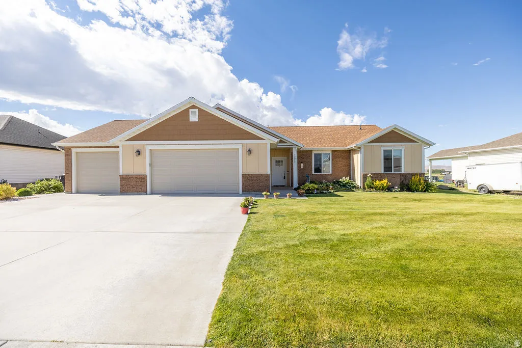 Ranch-style exterior with a three-car garage, concrete driveway, and a gabled roof