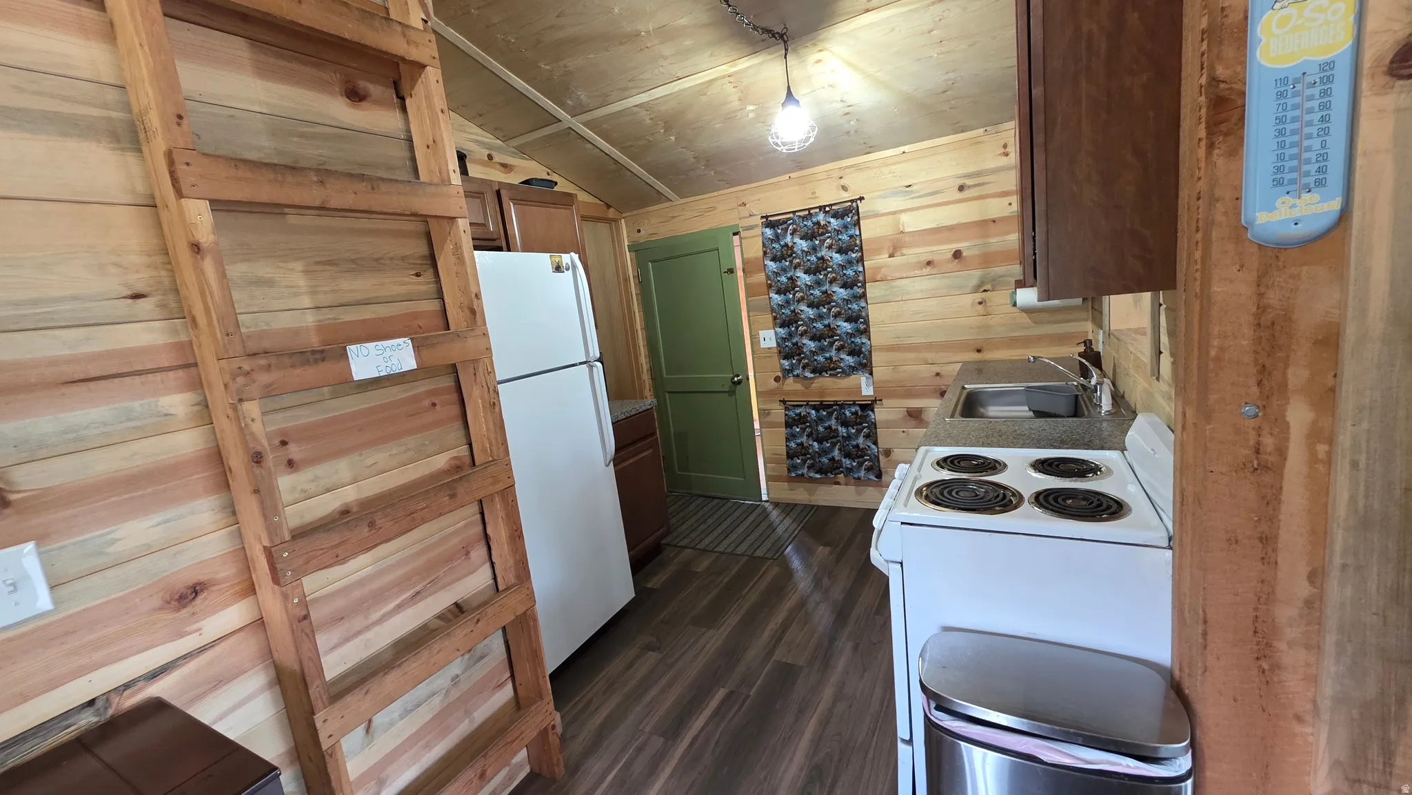 Compact kitchen featuring wood-finish flooring, wood plank walls, and a wood plank ceiling